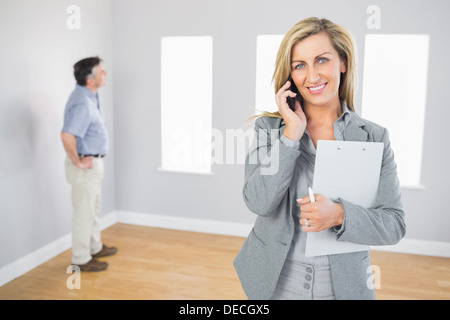 Happy realtor calling someone with her mobile phone Stock Photo