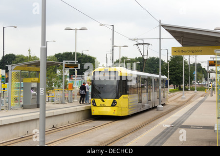 Droylsden to Bury tram on the Manchester Metrolink system, stopped at Velopark tram station on Ashton New Road. Stock Photo