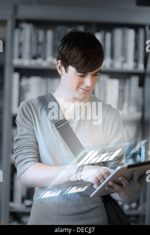 Focused student analysing graphs on his digital tablet Stock Photo
