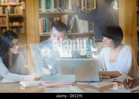 Focused mature students working together on new technologies Stock Photo