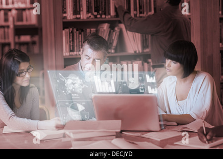 Focused mature students working together on digital interface Stock Photo