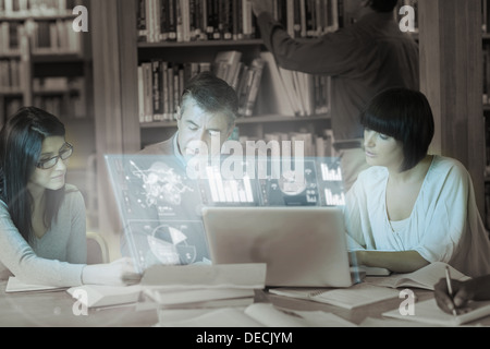 Serious mature students working together on digital interface Stock Photo
