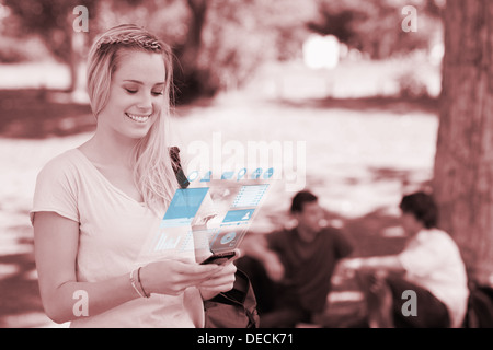 Cheerful pretty blonde working on her digital smartphone Stock Photo
