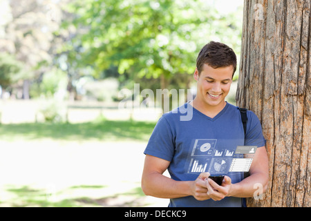 Smiling handsome student using his digital smartphone Stock Photo