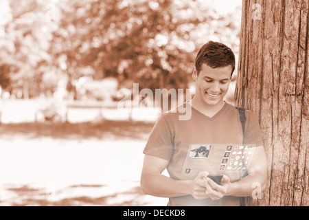 Cheerful handsome student using his digital phone Stock Photo