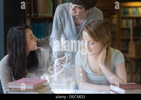 Smiling students working together with futuristic interface Stock Photo