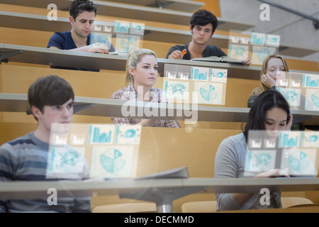 Focused students in lecture hall working on their futuristic tablet Stock Photo