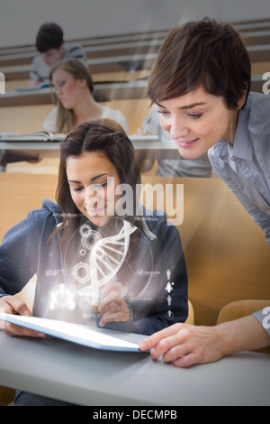 Student and teacher using futuristic hologram to learn biology from tablet Stock Photo