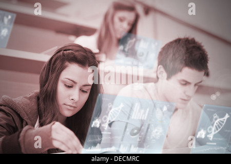 Students using futuristic hologram to learn about science from tablet pc Stock Photo