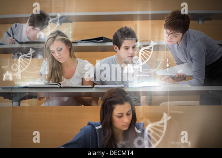 Students using futuristic interface to learn about science from tablet pcs Stock Photo