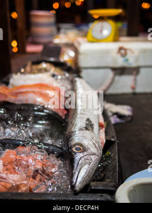 Sales man holding Fresh raw barracuda fish in market Stock Photo