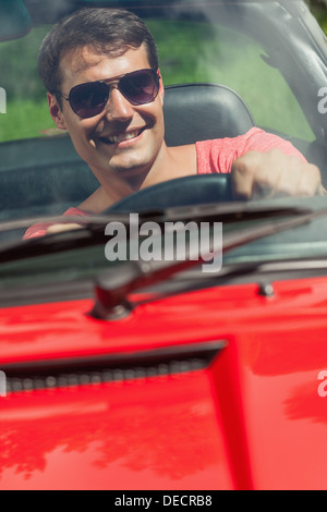 Cheerful handsome man driving his cabriolet Stock Photo