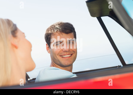 Smiling man looking at his pretty girlfriend while driving Stock Photo
