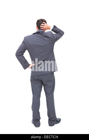 Young businessman standing back to camera scratching his head Stock Photo