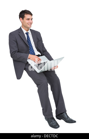Smiling businessman sitting using a laptop Stock Photo