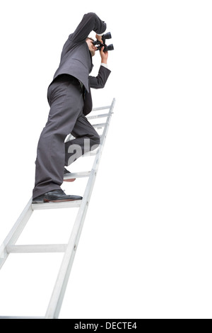 Low angle view of businessman standing on ladder using binoculars Stock Photo
