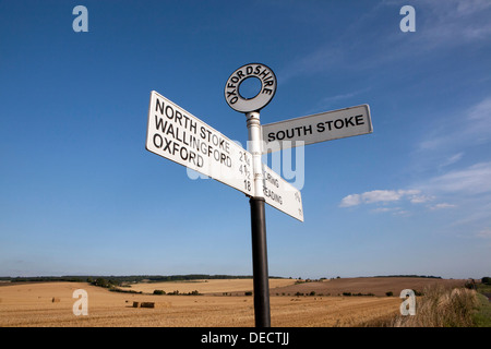 An old Oxfordshire cast iron road sign against a blue sky. Stock Photo