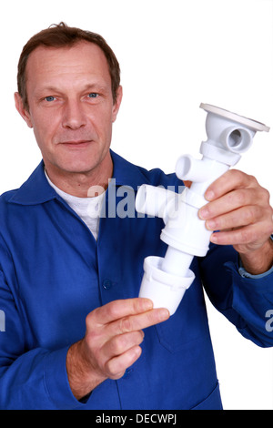 Plumber holding replacement part Stock Photo