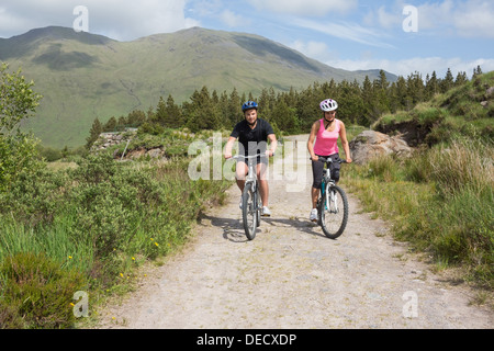 Athletic couple cycling through countryside Stock Photo