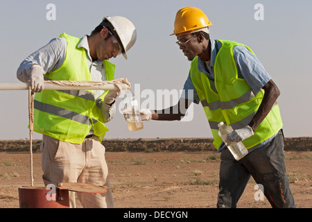 Taking water samples from bore hole, to test quality on industrial gold mining complex, Mauritania, NW Africa Stock Photo