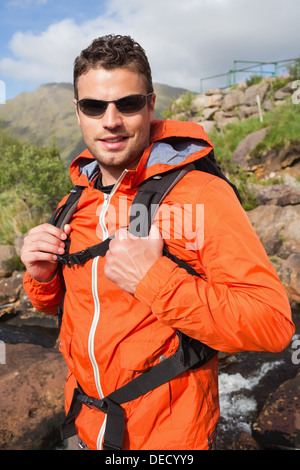 Man wearing rain jacket and sunglasses smiling at camera Stock Photo