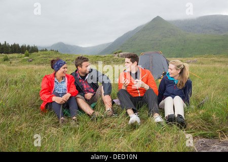 Friends chatting together on camping trip Stock Photo