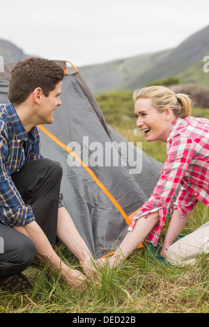 Smiling couple pitching their tent together Stock Photo