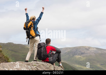Excited couple reaching the top of their hike Stock Photo