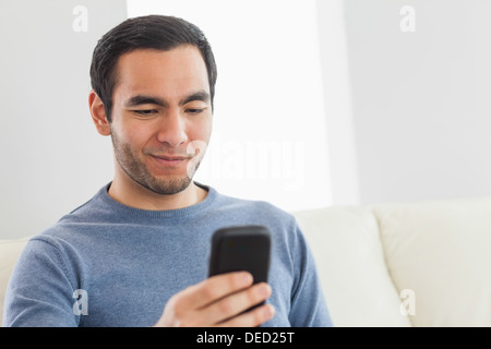 Smiling casual man text messaging Stock Photo