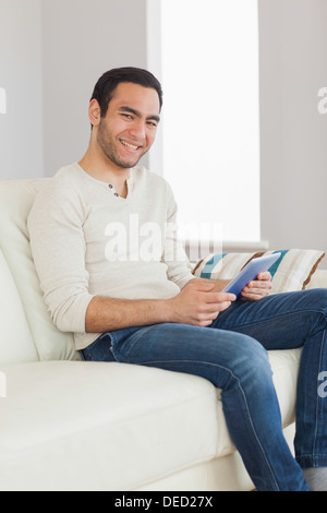 Smiling handsome man using his tablet Stock Photo