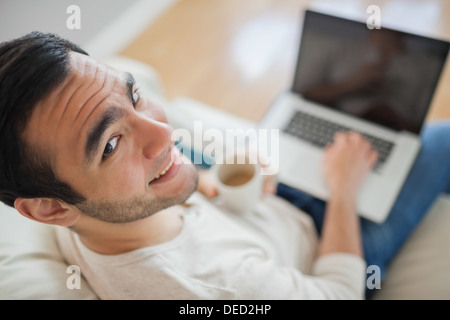 High angle view of smiling young man using his laptop Stock Photo