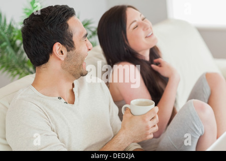 Cheerful couple relaxing together on sofa Stock Photo
