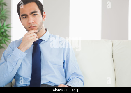 Thoughtful classy businessman sitting on cosy sofa Stock Photo