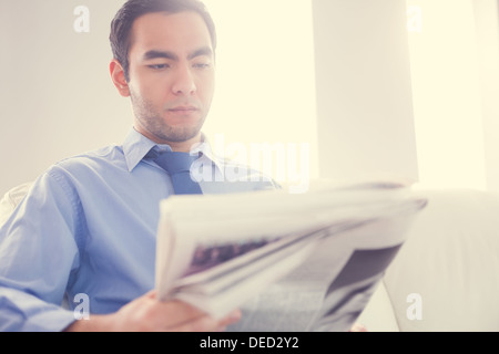 Serious handsome businessman reading newspaper Stock Photo