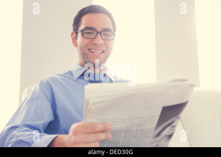 Happy man looking at camera and holding a newspaper Stock Photo