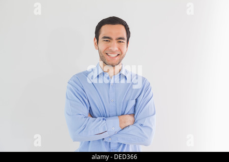 Smiling man standing with arms crossed and looking Stock Photo
