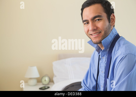 Content man looking at camera and relaxing sitting on his bed Stock Photo