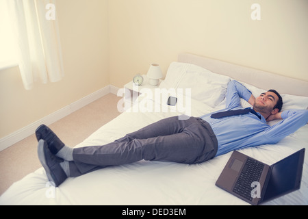 Pleased man relaxing on his bed Stock Photo