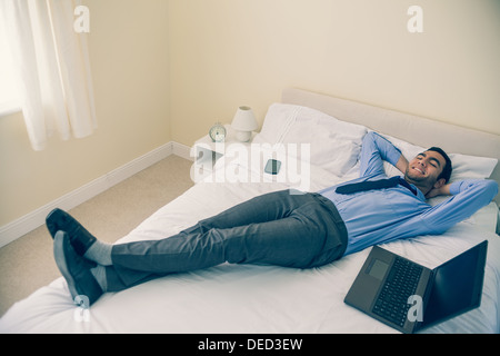 Cheerful man relaxing on his bed Stock Photo