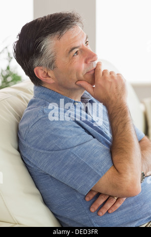 Thinking man sitting on sofa Stock Photo