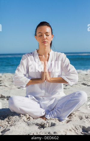 Woman practicing yoga at the beach Stock Photo
