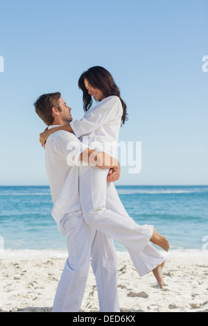 Happy man holding woman in arms Stock Photo