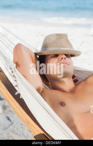 Man wearing straw hat lying in hammock Stock Photo