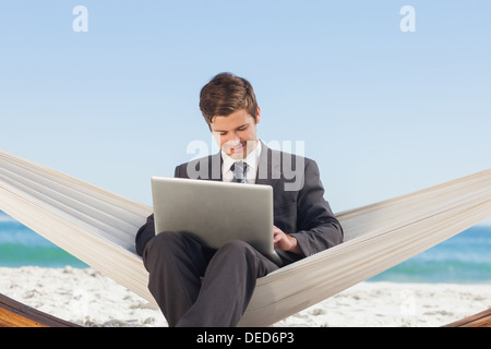 Businessman typing on his laptop in a hammock Stock Photo