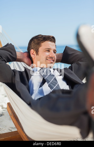 Happy businessman lying in hammock Stock Photo