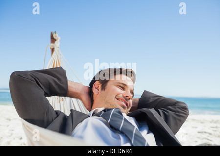 Businessman relaxing in hammock Stock Photo