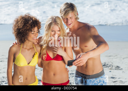 Three friends looking at photos on digital camera Stock Photo