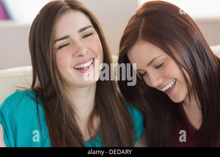 Two laughing friends sitting on the couch Stock Photo