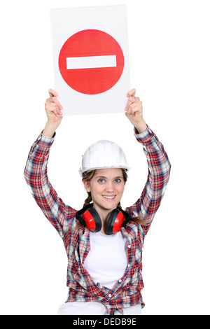 Worker holding warning sign Stock Photo