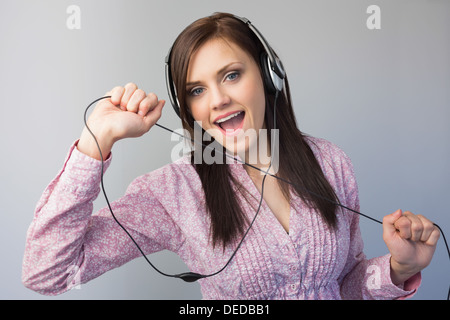 Cheerful young woman listening to music in headphones Stock Photo - Alamy
